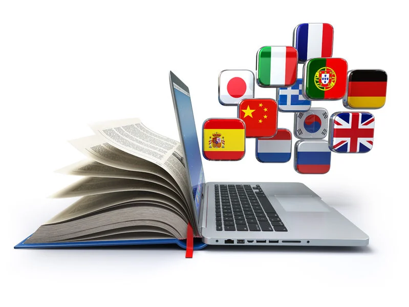 An open book and laptop surrounded by language flags